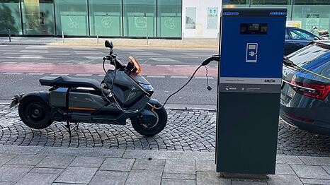Eine E-Ladestation der Stadtwerke M&uuml;nchen. Ein E-Roller tankt gerade &Ouml;kostrom.