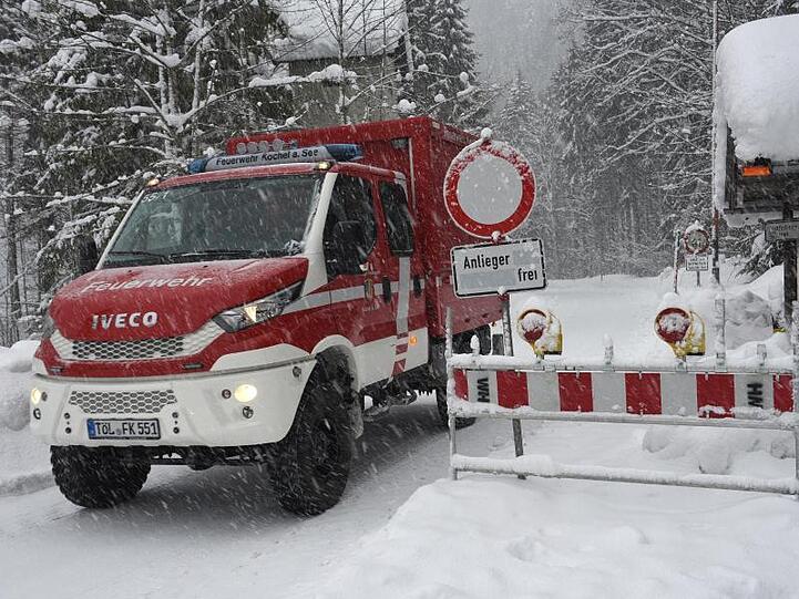 Ein Feuerwehrfahrzeug fährt bei Bad Tölz derzeit mit der Außenwelt verbindet. Foto: Angelika Warmuth