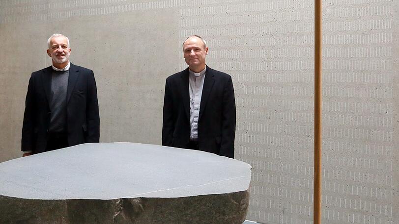 Pfarrer Bodo Windolf (r.) und Architekt Andreas Hlawaczek hinter dem Altarstein und dem Altarkreuz.