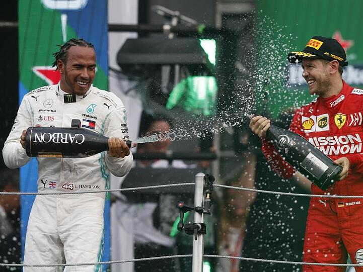 Champus für den Sieger: Lewis Hamilton feiert, Sebastian Vettel zwangsläufig mit.