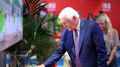 Steinmeier am Nintendo-Messestand, wo er digitales Bogenschie&szlig;en als Sportart ausprobierte.