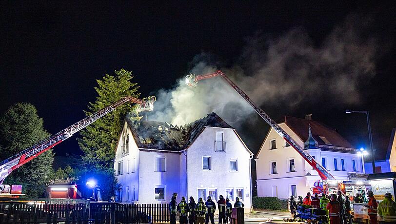 Einsatzkr&auml;fte der Feuerwehr sind mit einer Drehleiter am Brand eines Dachstuhls in N&uuml;rnberg besch&auml;ftigt.