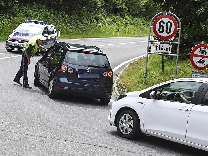 Hier geht's nicht weiter: Ein Polizist hält Autos auf einer Straße bei Innsbruck an.