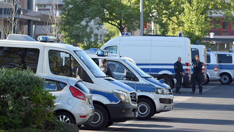 Fahrzeuge der Polizei stehen im Bonner Stadtteil Tannenbusch auf einem Parkplatz. Seit den frühen Morgenstunden führte die Polizei hier und in anderen Orten um Bonn eine Razzia gegen Drogenhandel durch.