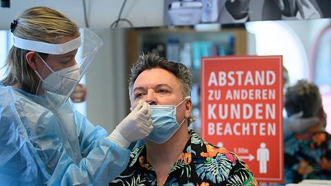 Ein Friseurmeister bekommt einen Schnelltest - auch Kunden brauchen den in Bayern.