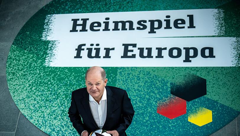 Bundeskanzler Olaf Scholz steht mit einem Fußball bei einem Fototermin. Bundeskanzler Olaf Scholz steht mit einem Fußball bei einem Fototermin.
