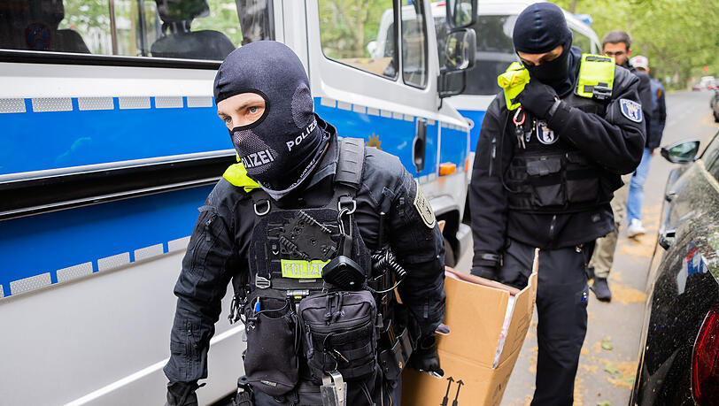 Polizisten tragen bei einer Hausdurchsuchung in Berlin-Kreuzberg einen Karton zu einem Fahrzeug. (Archiv) Polizisten tragen bei einer Hausdurchsuchung in Berlin-Kreuzberg einen Karton zu einem Fahrzeug. (Archiv)