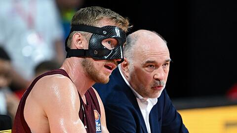 Niels Giffey (l) und Trainer Pablo Laso von München sitzen in einer Pause zusammen.