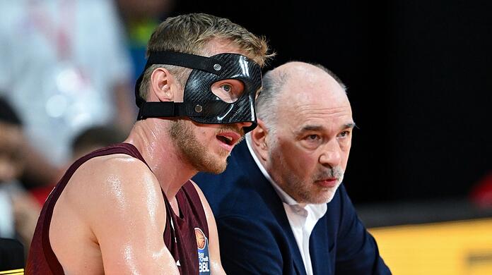 Niels Giffey (l) und Trainer Pablo Laso von München sitzen in einer Pause zusammen.