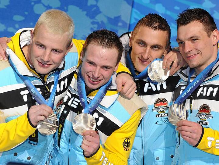 Der Bob-Vierer um Andre Lange (l) zeigt posiert stolz mit Silbermedaille.