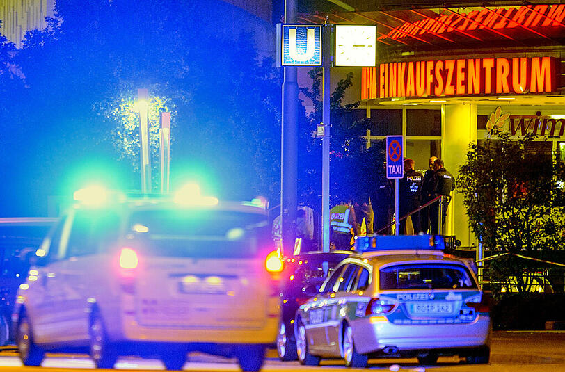 Ein Einsatzfahrzeug fährt am frühen Samstagmorgen mit Blaulicht vor dem Olympia Einkaufszentrum in München, in dem am Vorabend Schüsse gefallen waren.