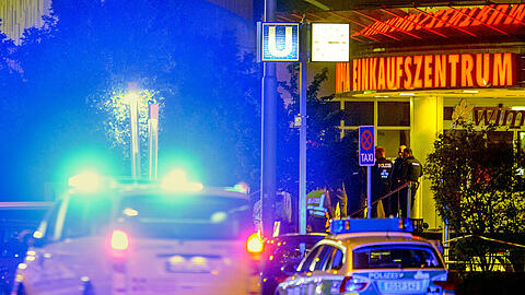 Ein Einsatzfahrzeug fährt am frühen Samstagmorgen mit Blaulicht vor dem Olympia Einkaufszentrum in München, in dem am Vorabend Schüsse gefallen waren.