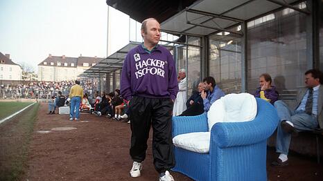 Farbenfroh auf Giesings H&ouml;hen: 1860-Trainer Karsten Wettberg im lilafarbenen Pullover vor wei&szlig;-blauer Coaching-Couch im Gr&uuml;nwalder Stadion.
