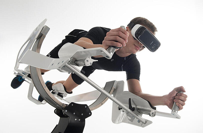 Der Benutzer stützt sich mit Armen und Beinen auf und kann durch seine Körperhaltung und Schwerpunktverlagerung das Gerät bewegen, mit der Brille erlebt er das Bild eines Flugsimulators, der durch seine Körperbewegung gesteuert wird.