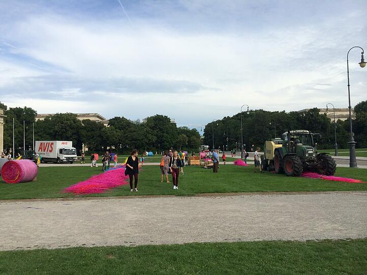Passanten wundern sich über den Traktor mit der &bdquo;Ballenpresse&ldquo;.