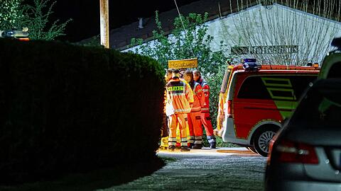 Helfer und ein Notarzt stehen in einer Kleingartenanlage in Wuppertal. Sie können nicht mehr helfen.