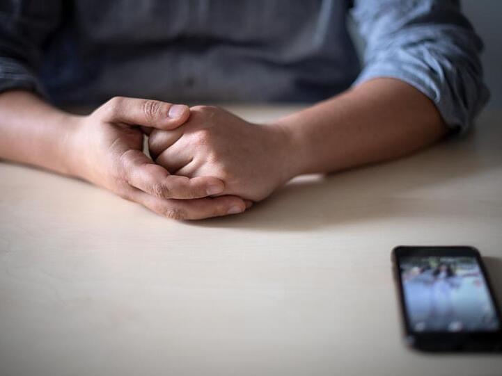 Ein Smartphone liegt vor einem Mann auf dem Tisch. Soziale Medien haben auch eine dunkle Seite. Besonders Kinder und Jugendliche machen immer wieder negative Erfahrungen.