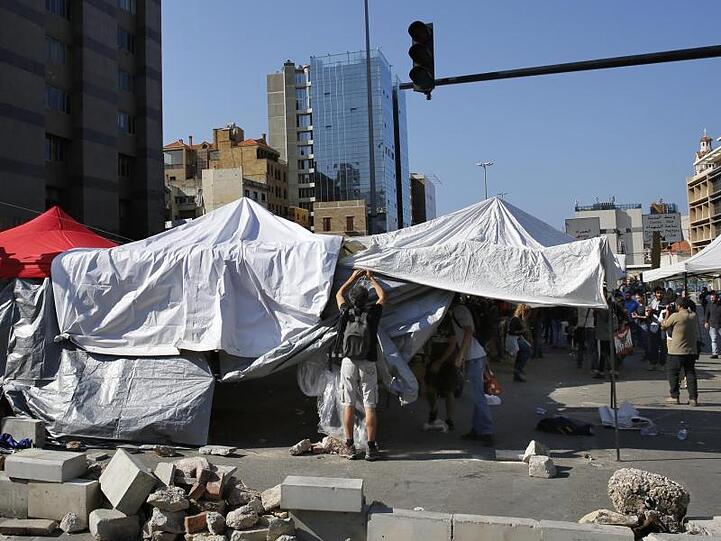 Regierungskritische Demonstranten bauen ihre Zelte auf einer Hauptstraße in der libanesischen Hauptstadt ab.