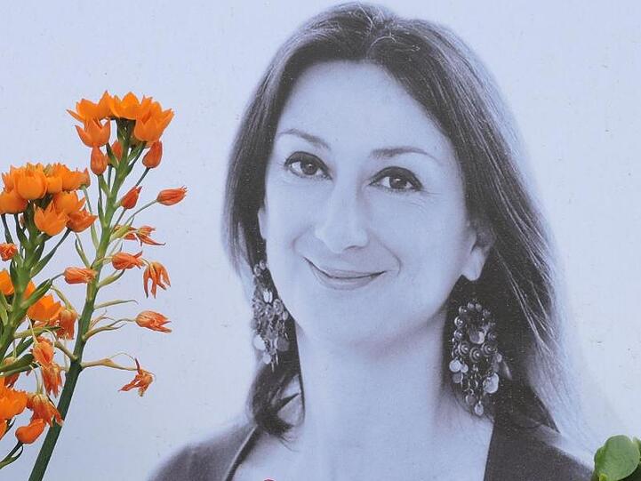 Am Fuß eines Denkmals vor dem Justizpalast erinnert ein Foto an Daphne Caruana Galizia.