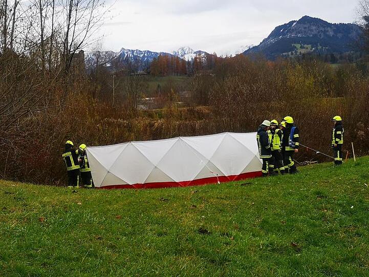 Feuerwehrleute stehen am Fundort der Leiche neben einem Sichtschutz. Foto: Benjamin Liss/dpa