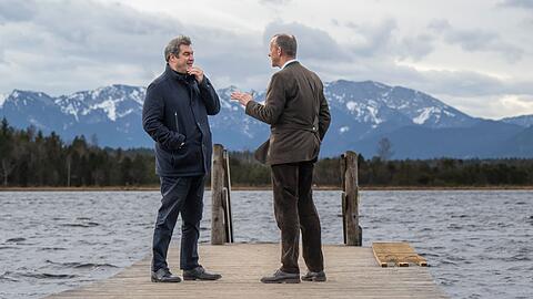 Markus Söder (l) und Friedrich Merz unterhalten sich während eines Spaziergangs am Ufer des Kirchsee.