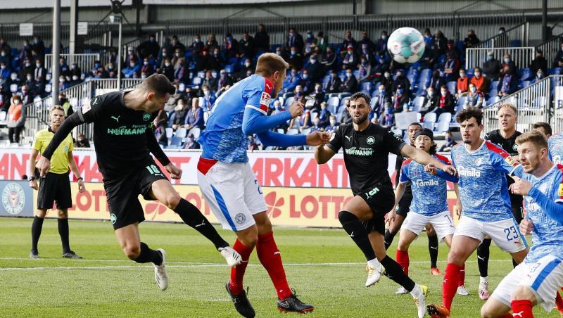 Fürths Branimir Hrgota (l) köpft gegen Kiels Hauke Wahl (2.v.l.) auf das Tor.