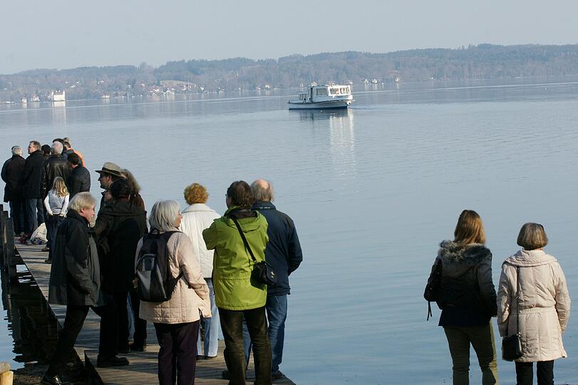Zuschauer blicken der "MS Schondorf" nach auf der ersten Fahrt im Starnberger See.