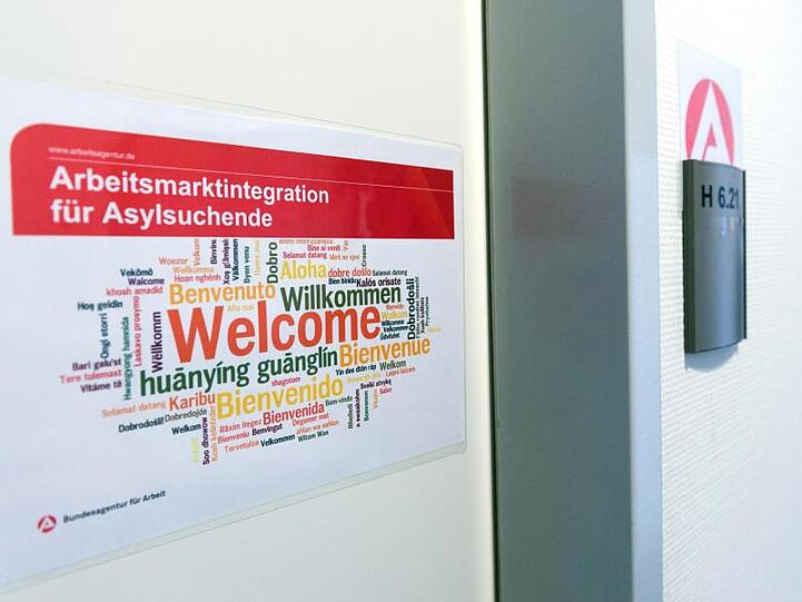 Ein Aufkleber "Arbeitsmarktintegration für Asylsuchende. Welcome" hängt in der Registrierungsstelle für Flüchtlinge in Berlin.
