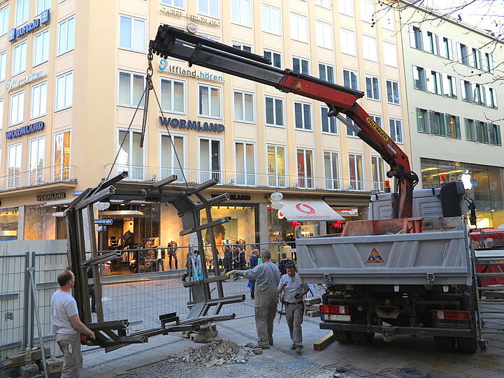 Mit dem Kran heben die Bauarbeiter den alten Aufzug zwischen Sperrengeschoss und Oberfläche am Marienplatz aus den Fugen.