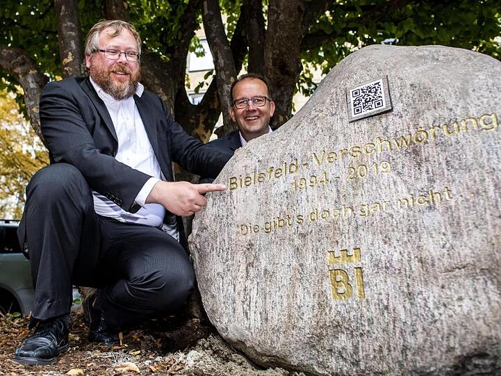 Martin Knabenreich (r), Geschäftsführer Bielefeld Marketing und Achim Held (l), Schöpfer der Bielefeld-Verschwörung, neben dem Denkmal.