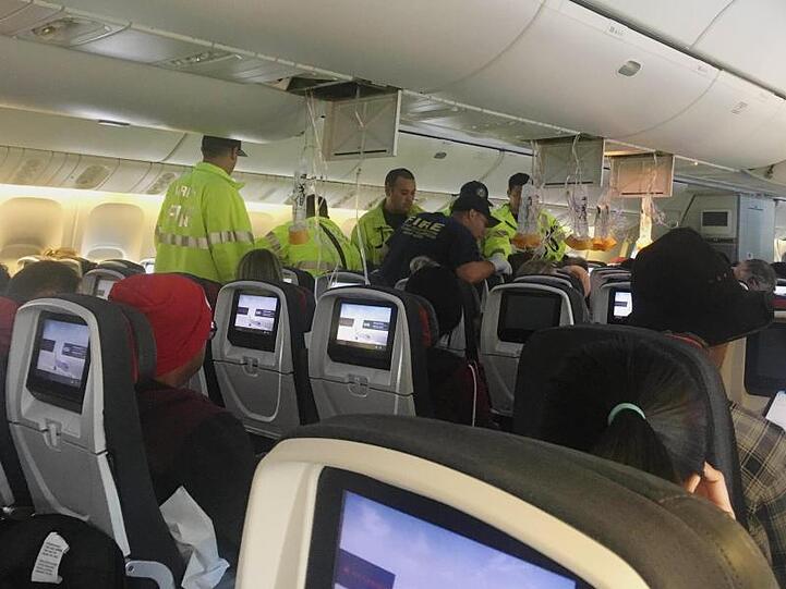 Das vom Hurricane Fall zur Verfügung gestellten Foto zeigt Einsatzkräfte, die sich nach einer außerplanmäßigen Landung um Passagiere in der Flugzeugkabine kümmern.