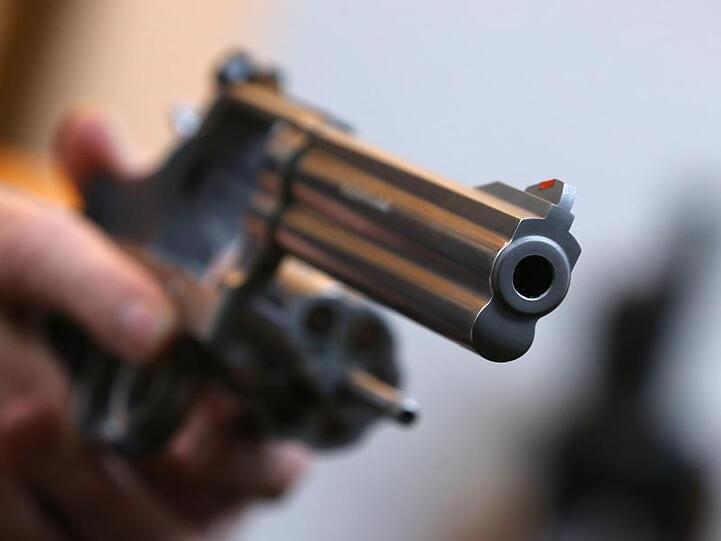 Ein Mann hält in einem Waffengeschäft einen Revolver des Herstellers Smith & Wesson. Foto: Karl-Josef Hildenbrand/Archiv