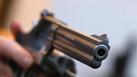 Ein Mann hält in einem Waffengeschäft einen Revolver des Herstellers Smith & Wesson. Foto: Karl-Josef Hildenbrand/Archiv