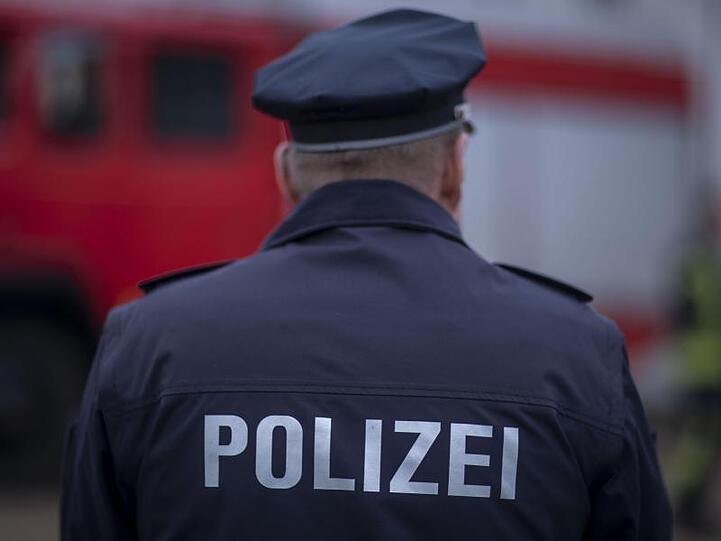 Ein Polizist steht vor einem Fahrzeug. Foto: Jens Büttner/dpa-Zentralbild/ZB/Illustration