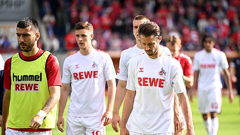 Die Kölner Spieler gehen nach der Niederlage in Heidenheim mit hängenden Köpfen vom Rasen.