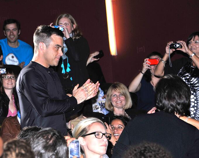 Weltstar im Fan-Gewusel: Robbie Williams verteilte Autogramme vor dem Mathäser-Kino.