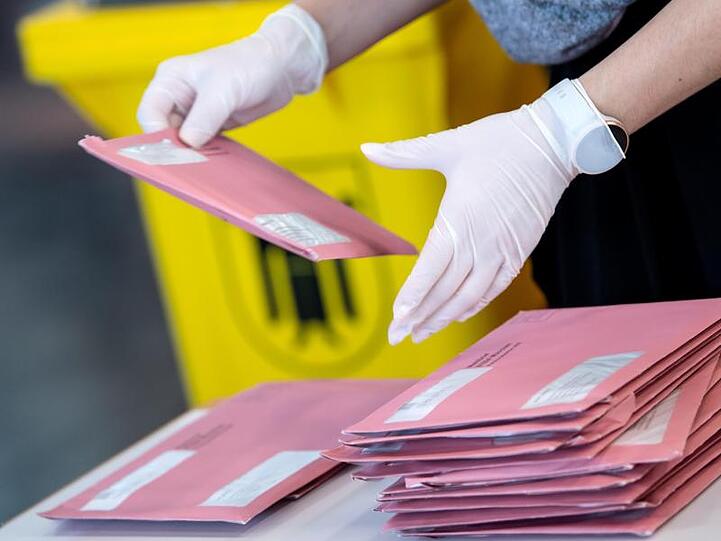 Wahlhelfer bereiten in München die Auszählung der Briefwahl vor.