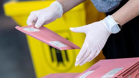 Wahlhelfer bereiten in München die Auszählung der Briefwahl vor.