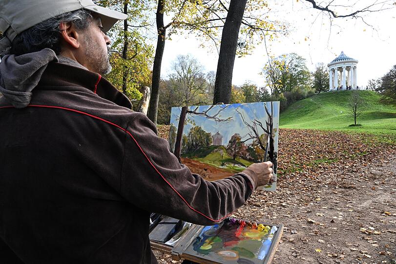 Der Maler Fernando Sorianello malt bei Sommerwetter im Englischen Garten die Herbststimmung am Monopteros.
