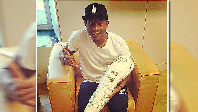 David Alaba präsentiert stolz den abgenommenen Gips, auf dem viele seiner Bayern-Kollegen unterschrieben hatten.