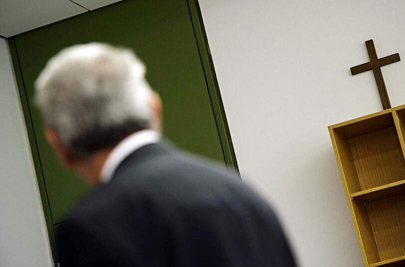 Der angeklagte Rentner Emrullah C. blickt im Landgericht München in Richtung eines Kreuzes. Er wurde zu lebenslanger Haft verurteilt.