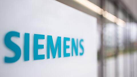 Das Logo des deutschen Industriekonzerns Siemens steht auf einer Stele am Eingang eines Bürogebäudes.