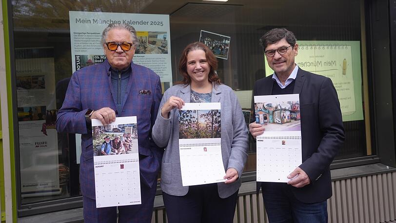 Schauspieler Michael Brandner (l.), Kommunalreferentin Jacqueline Charlier und der Projektinitiator Matthias Müller präsentieren den Fotokalender vor dem Standl 19 am neuen Elisabethmarkt. Das gemeinnützige Projekt "Mein München 2025" darf das städtische Standl, in das erst im Januar ein Marktgeschäft einzieht, bis 30. Dezember als Zwischennutzung nutzen. Schauspieler Michael Brandner (l.), Kommunalreferentin Jacqueline Charlier und der Projektinitiator Matthias Müller präsentieren den Fotokalender vor dem Standl 19 am neuen Elisabethmarkt. Das gemeinnützige Projekt "Mein München 2025" darf das städtische Standl, in das erst im Januar ein Marktgeschäft einzieht, bis 30. Dezember als Zwischennutzung nutzen.
