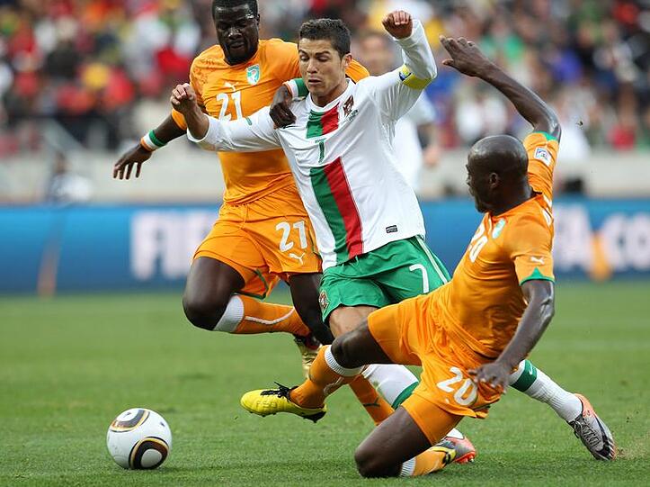 Cristiano Ronaldo (M.) wird von Demel (r) und Eboue (l) in die Mangel genommen.