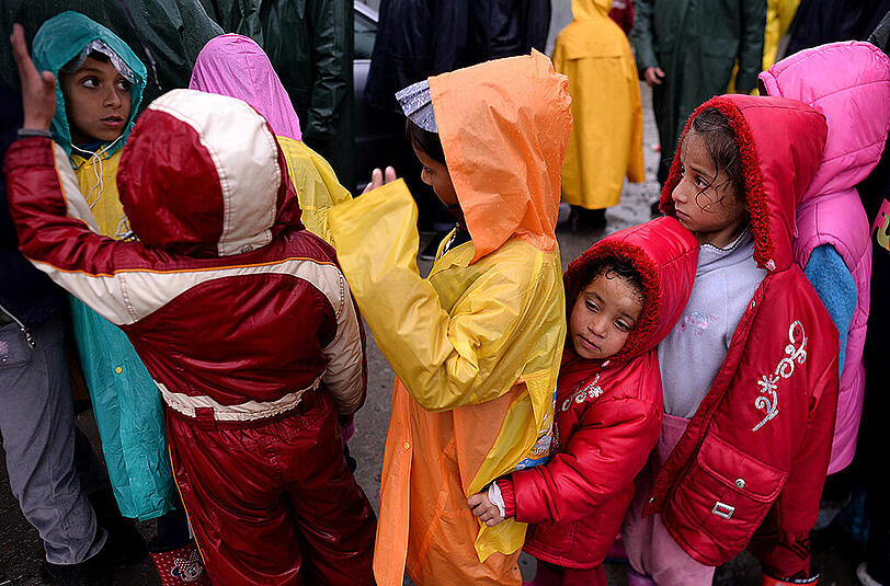 Hunderte Flüchtlinge aus dem Lager in Idomeni durchqueren einen reißenden Fluss auf griechischer Seite, um illegal nach Mazedonien zu gelangen.