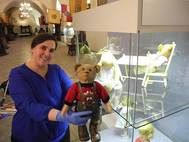 Kuratorin Veronika Genslein hält im Museum in Franken einen alten Teddybär in die Kamera. Foto: Christiane Bosch/Archiv