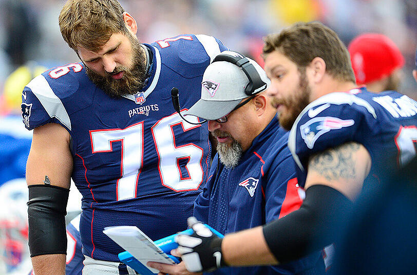 Patriots-Tackle Sebastian Vollmer (links) im Taktikgespräch mit Trainer und Kollege.