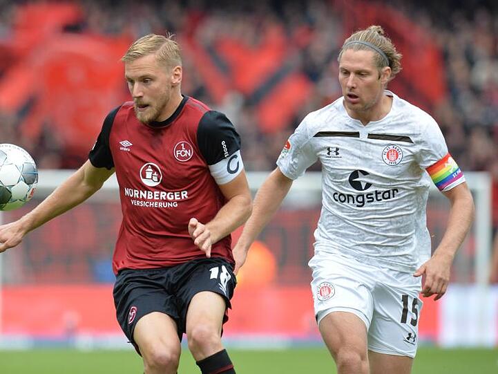 Der Nürnberger Hanno Behrens (l.) spielt gegen St. Paulis Daniel Buballa. Foto: Timm Schamberger/dpa