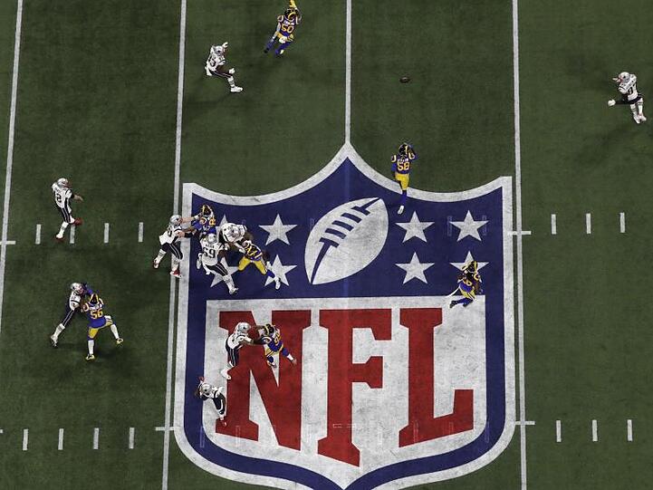 Die Los Angeles Rams versuchen einen Spielzug der Patriots mit einem Pass von Tom Brady (l, 12) zu Rob Gronkowski (r, 87) zu unterbinden.