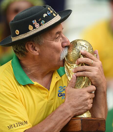 Abschiedskuss: Der mittlerweile verstorbene brasilianische Fußballfan Clóvis Acosta Fernandes küsst beim 1 : 7 gegen Deutschland den WM Pokal.